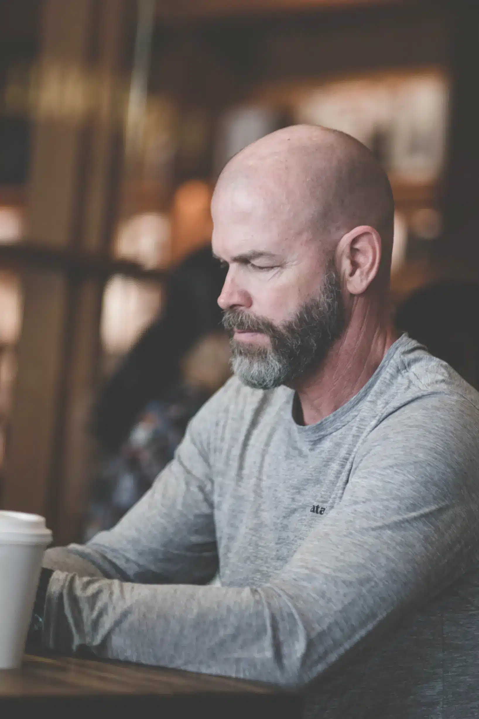 bald man sitting in a coffee shop
