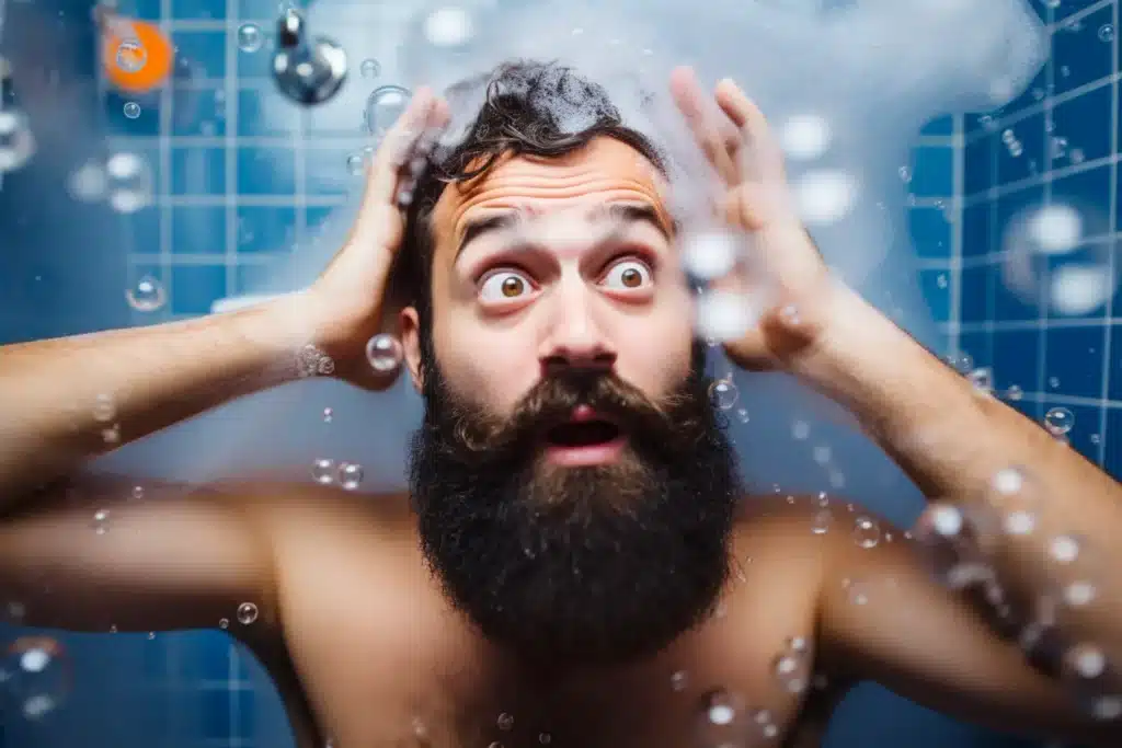 bearded man with a shocked expression standing in shower