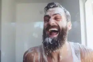 man smiling with soap suds all over him